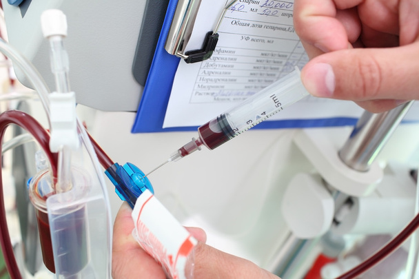 Doctor collects blood from the medical device - Foto, Bild