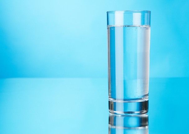 Glass of water on blue background - Photo, Image