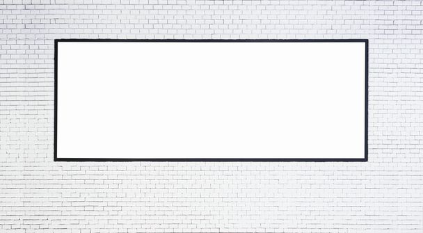 Bespotten van lege Banner met zwart frame op witte bakstenen muur - Foto, afbeelding
