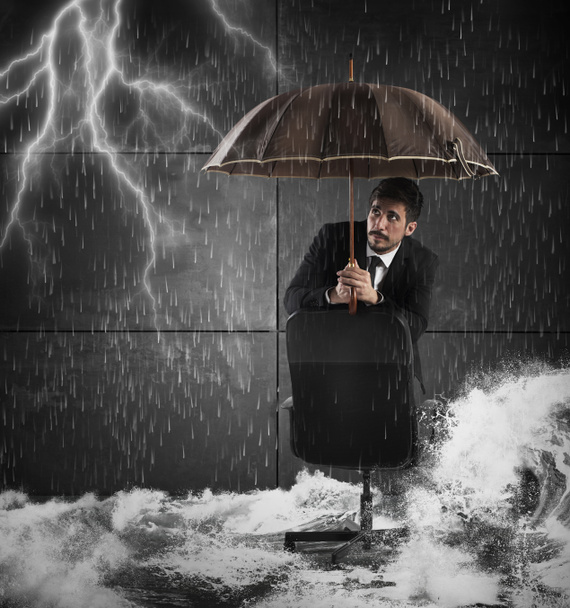ビジネスマンは傘で身を守る - 写真・画像