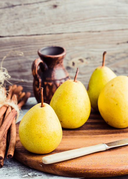 yellow pear on a wooden board, cinnamon sticks,selective focus - Foto, Imagem