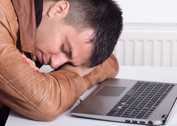Mann schläft über Laptop - Foto, Bild