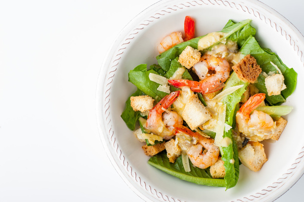 Caesar salad with shrimps on the white background top view - Foto, Bild