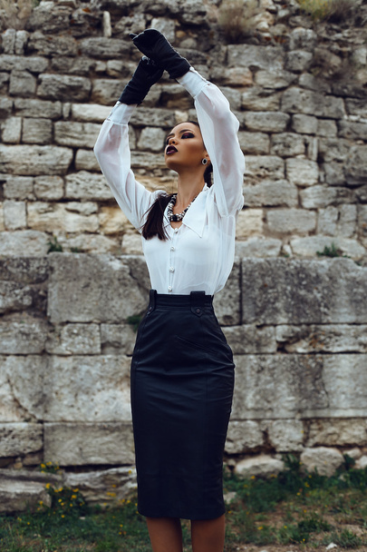 elegant brunette wears white shirt, leather skirt and gloves - Foto, Imagen