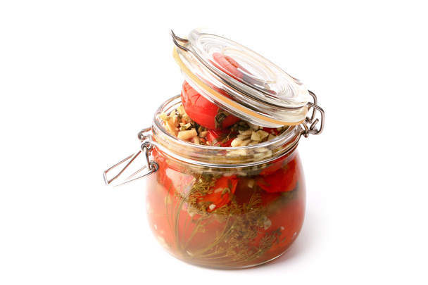 canned pickled tomatoes in a glass jar isolated on white background rustic style - 写真・画像