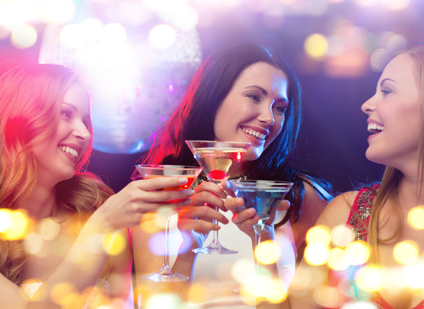 smiling women with cocktails at night club - Фото, изображение