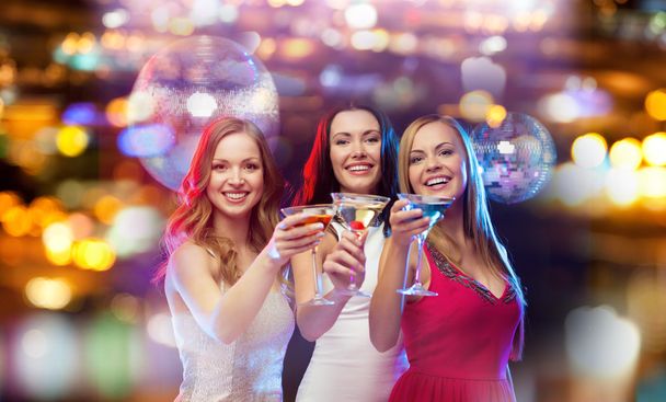 smiling women with cocktails at night club - Zdjęcie, obraz