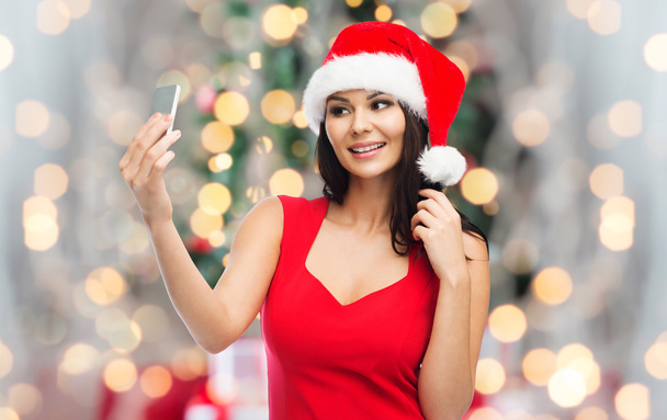 woman in santa hat taking selfie by smartphone - Foto, Imagem