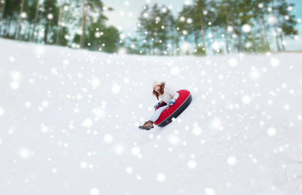 happy teenage girl sliding down on snow tube - Foto, Imagem