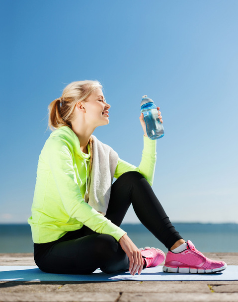 woman drinking water after doing sports outdoors - Foto, immagini
