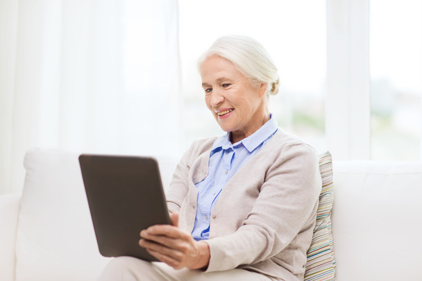 happy senior woman with tablet pc at home - Foto, afbeelding