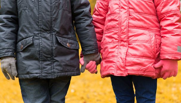 close up of girl and boy holding hands outdoors - Foto, Imagen