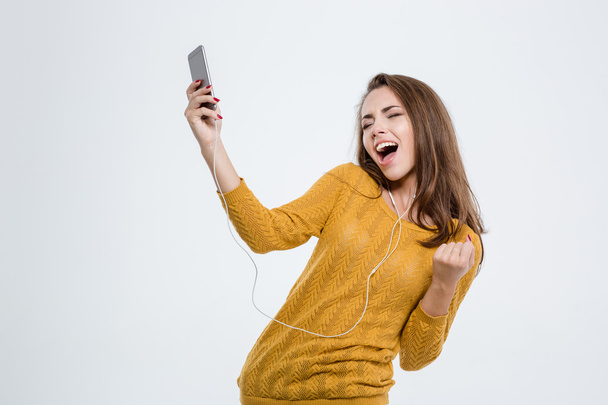 Woman listening music in headphones and dancing - Photo, image