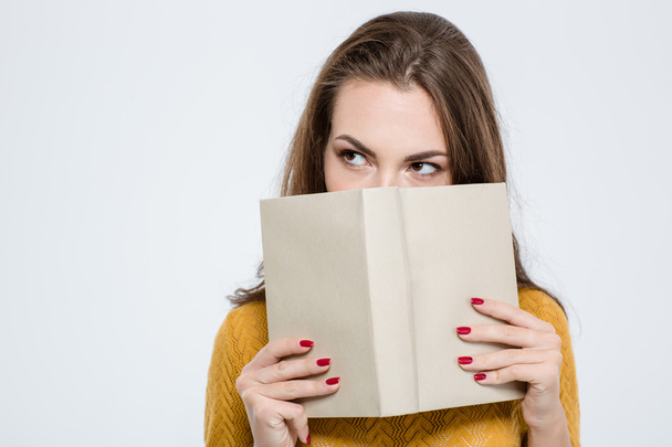 Woman covering her face with book - 写真・画像