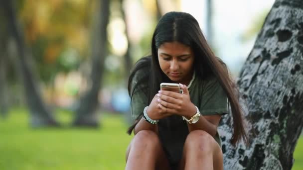 Teini tyttö istuu yksin leikkii hänen matkapuhelin
 - Materiaali, video