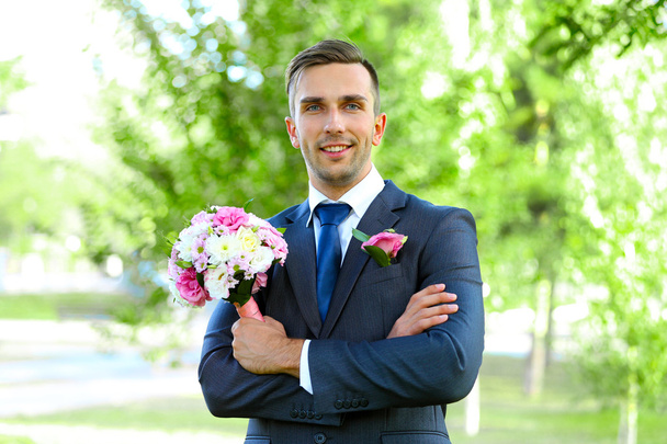 Groom holding wedding bouquet   - Fotografie, Obrázek