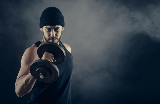 man with cap lifting weights - 写真・画像