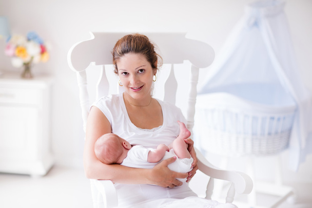Mother and newborn baby in white nursery - Photo, Image