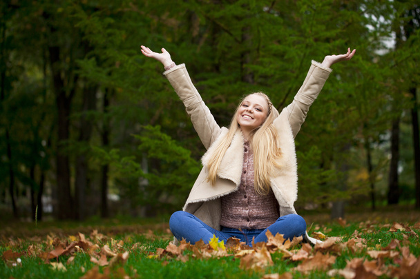 Joven mujer rubia feliz caminando en el parque de otoño
 - Foto, Imagen