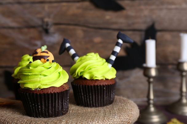 Halloween cupcakes on table on wooden wall background - Foto, imagen