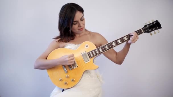 Braut spielt Gitarre auf ihrem Hochzeitskleid - Filmmaterial, Video