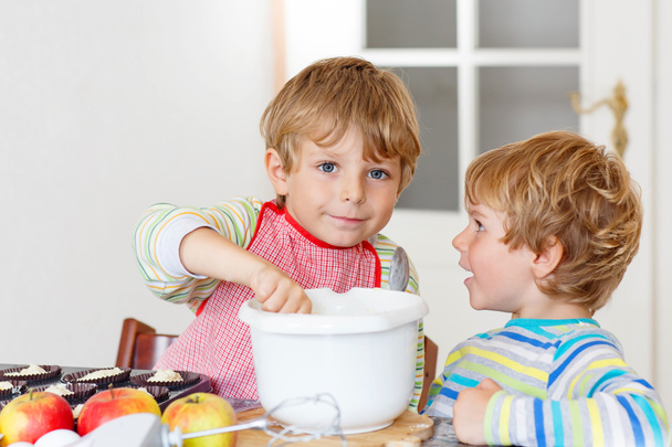 Два маленьких мальчика пекут яблочный пирог в помещении
 - Фото, изображение