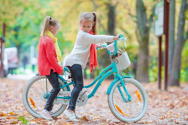 Aranyos kislány, a biciklizés, a szép őszi napon a szabadban - Fotó, kép