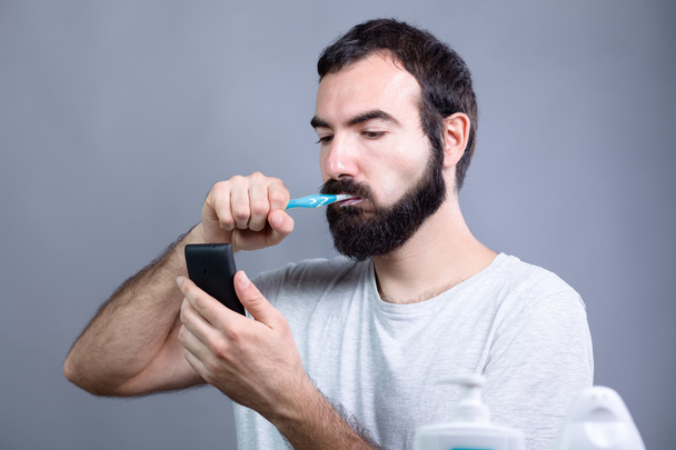 Άνθρωπος με οδοντόβουρτσα και Smartphone - Φωτογραφία, εικόνα