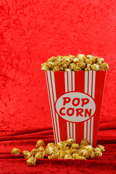 Caramel popcorn in a decorative red and white popcorn cup - 写真・画像