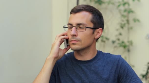 Mies puhuu puhelimessa valkoisessa lähikuva
 - Materiaali, video