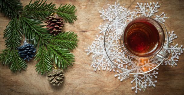 Glass Cup of tea on an old rustic table with pine branch.New yea - Photo, Image