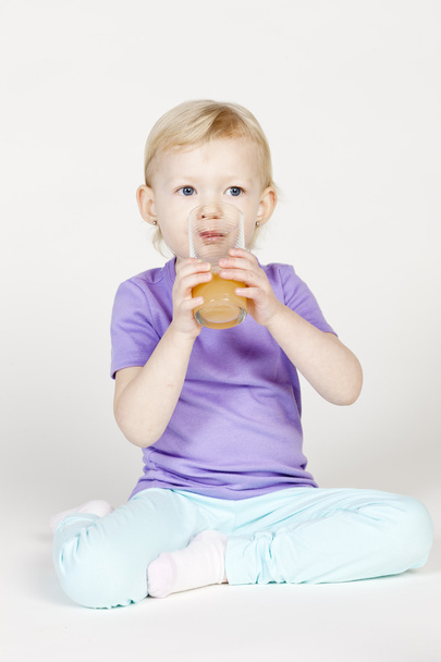 Little girl drinking orange juice - Zdjęcie, obraz