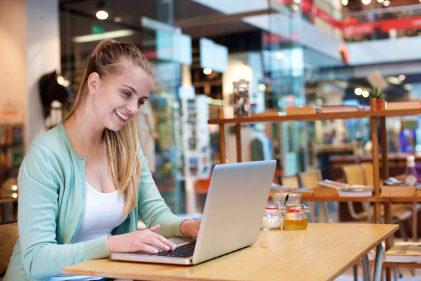 Smiling female student studying with laptop - Foto, Bild