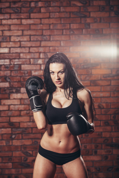 Young sexy girl with boxing gloves, on the background wall of red brick. - Foto, immagini