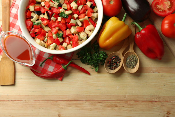 Ratatouille before cooking and ingredients, on wooden background - Foto, Imagem