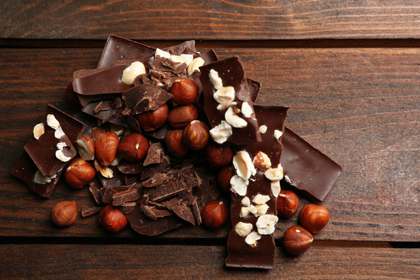 Chocolate pieces with nuts on wooden background - Foto, Imagem