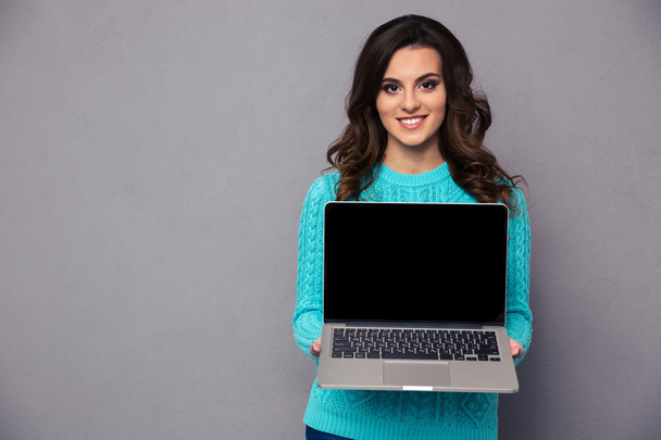 Femme souriante montrant écran d'ordinateur portable vierge
 - Photo, image