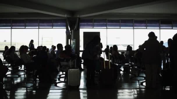 Unrecognizable silhouettes of people and luggage at airport terminal - Footage, Video
