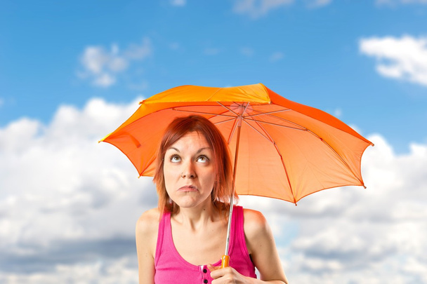 Sad girl holding an umbrella over white background - Photo, Image