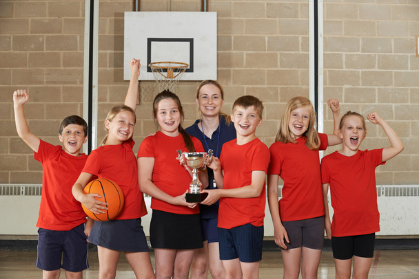 Victorious School Sports Team With Trophy In Gym - Valokuva, kuva