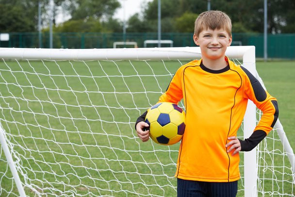 Portrait Of Goal Keeper Holding Ball On School Soccer Pitch - Foto, afbeelding