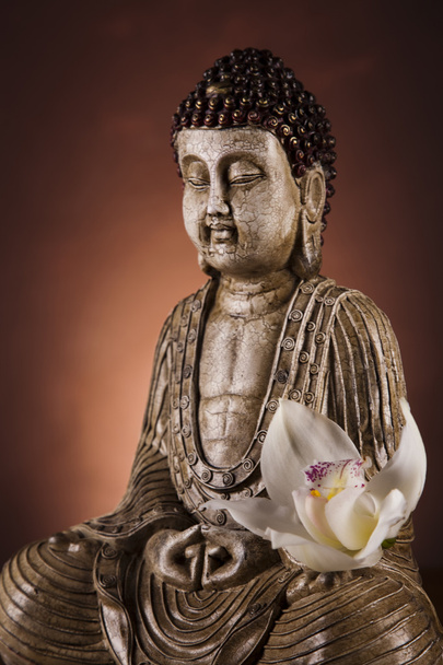 Estatua de Buda con flor de orquídea
 - Foto, Imagen