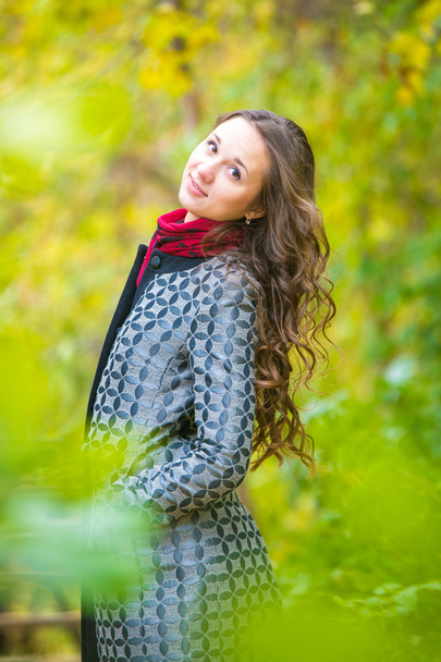 Portrait of a happy girl walking in the autumn forest - Fotoğraf, Görsel