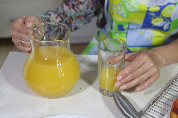 La mujer sostiene un vaso con jugo de naranja
 - Foto, imagen