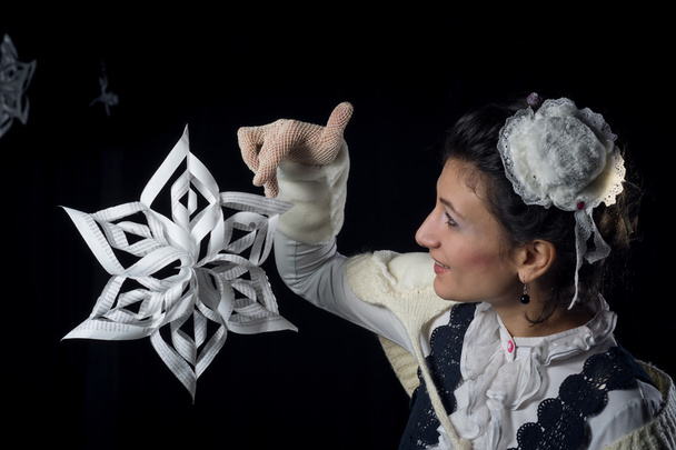 señora antigua jugando con un copo de nieve hecho a mano de papel
 - Foto, Imagen