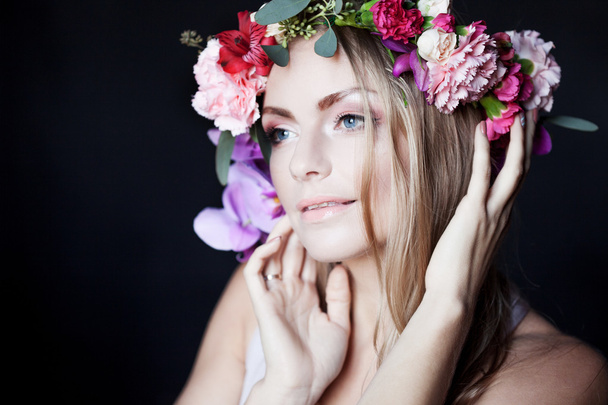 portrait  young beautiful woman in wreath of flowers, black background - Fotó, kép