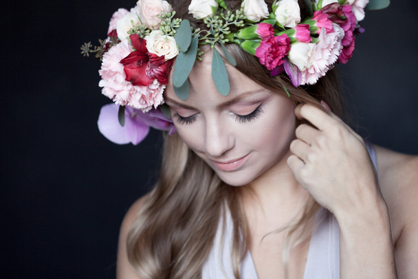 portrait  young beautiful woman in wreath of flowers, black background - Foto, afbeelding