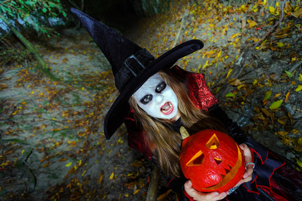 Little girl dressed in witch costume in Halloween forest - Foto, Bild