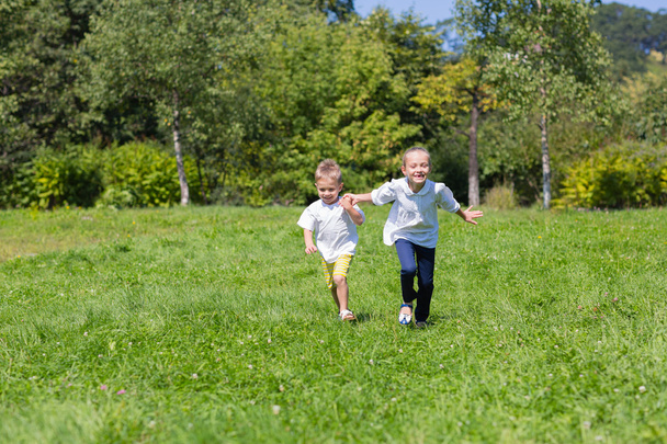 Boy and girl running on the lawn - Foto, imagen