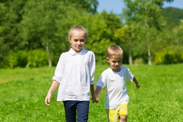 Brother and sister walk on the grass - Fotoğraf, Görsel